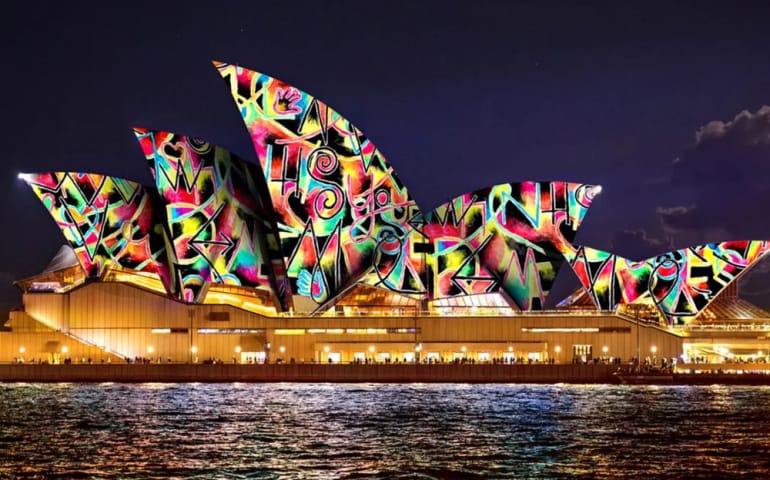 Waterfront restaurant in Sydney illuminated with vibrant Vivid Sydney 2025 lights