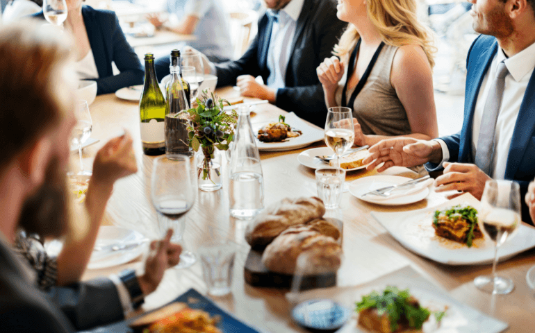 Business professionals enjoying a group lunch at a modern restaurant setting.