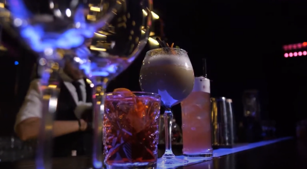 Cocktails on the bar counter with the bartender in the background