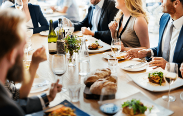 Business professionals enjoying a group lunch at a modern restaurant setting.