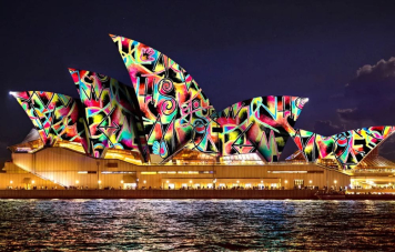 Restaurant au bord de l'eau à Sydney illuminé par les lumières vibrantes Vivid Sydney 2025